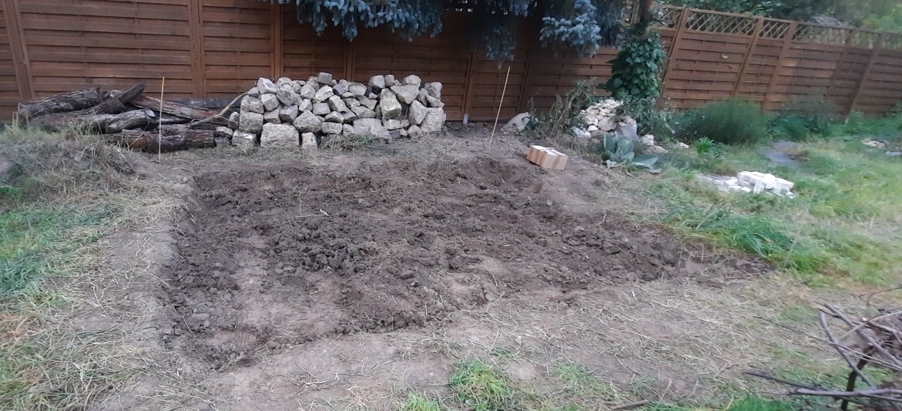 Aushub fürs Sandbeet mit Gestaltungsmaterialien im Hintergrund