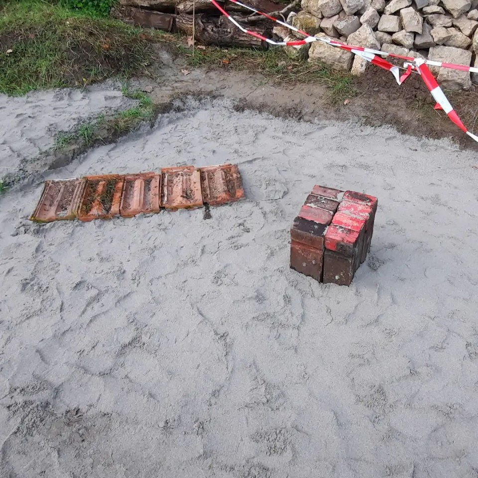 Sandbeet mit Trittholz und Dachziegel