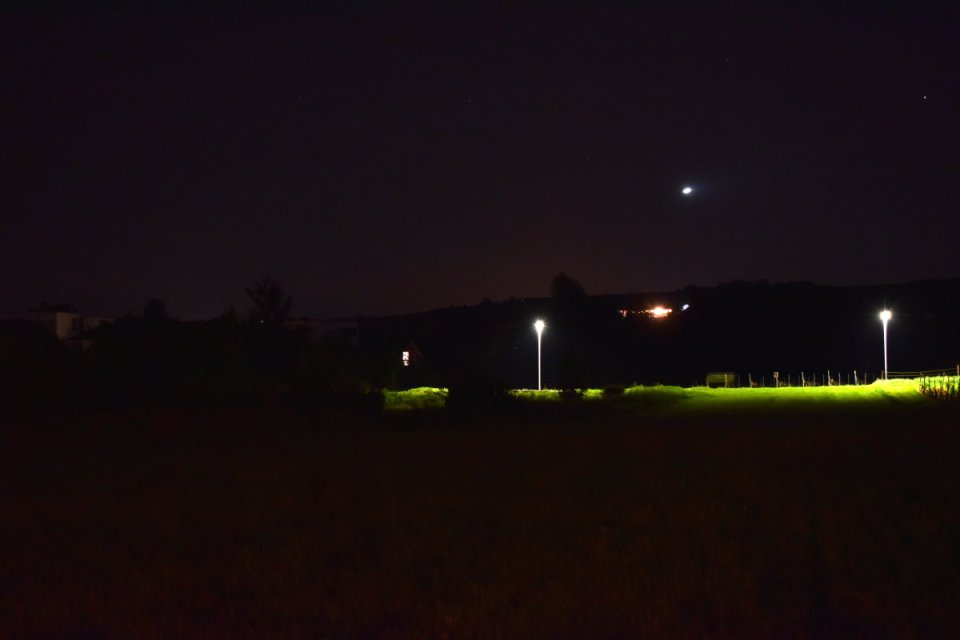 Straße mit gleißendem Licht durchschneidet Feld