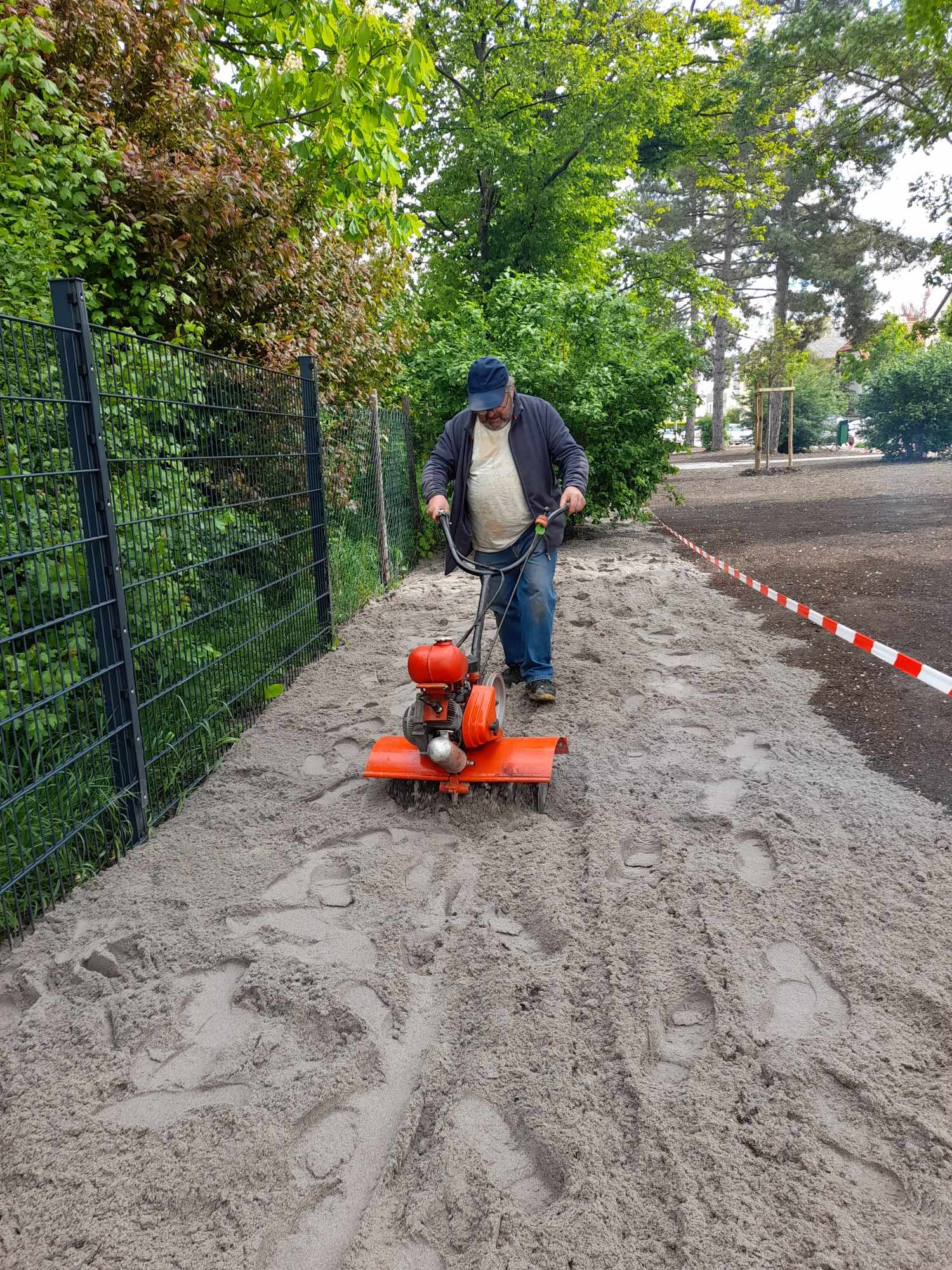 Sand wird mit der Fräse in die Erde gemischt