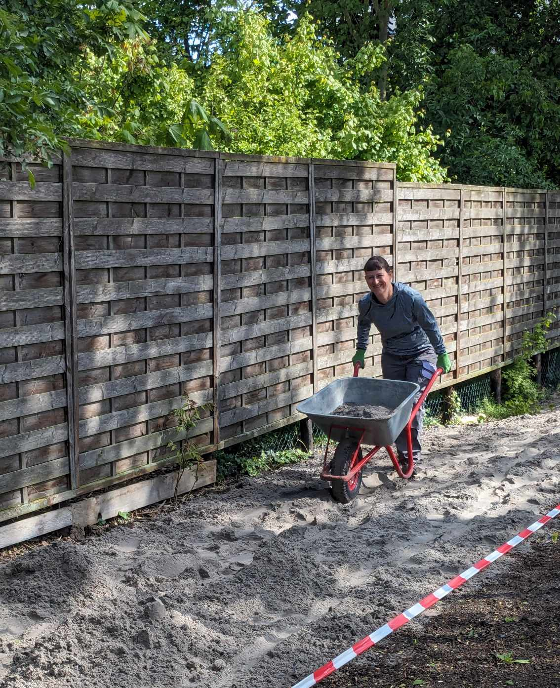 Sand wird im Bereich des künftigen Blühstreifens verteilt